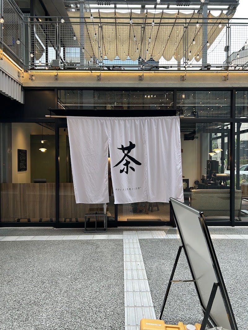 ガラス張りのテラス棟に下がる白い暖簾。墨で「茶」と書かれている。